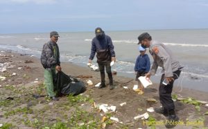 Anggota Polsek Pedes, bersih bersih lingkungan pantai Samudra Baru. (Lintasbatas.news)