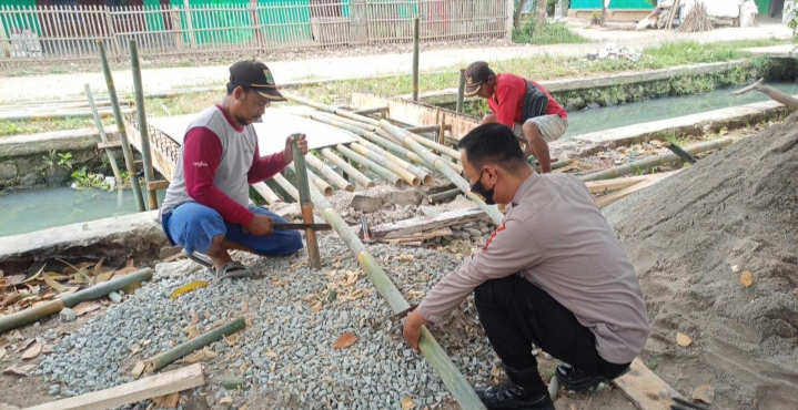 Anggota Polsek Pedes, Bantu Warga Gotongroyong Bangun Jembatan