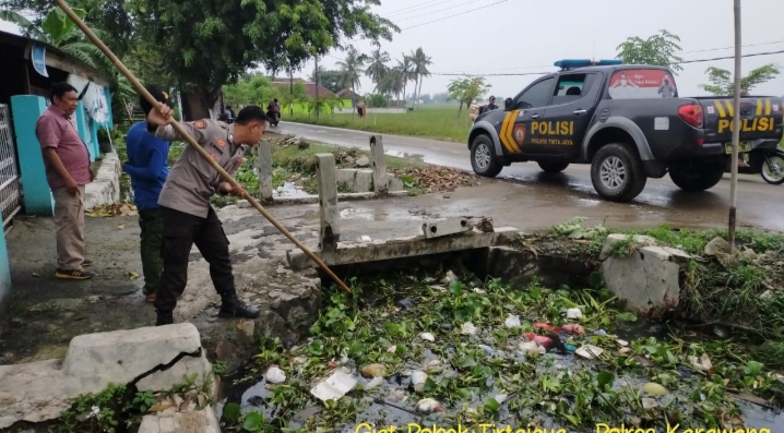 Antisipasi Banjir, Polsek Tirtajaya Bersama Warga Bersihkan Eceng Gondok di Saluran Air